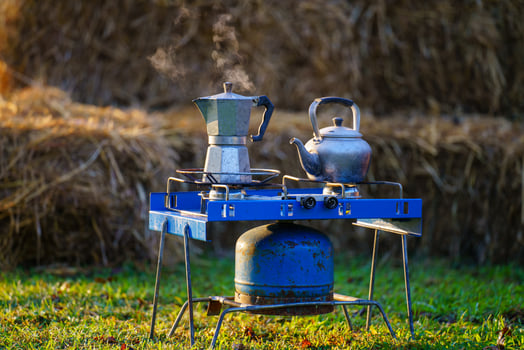 Moka pot on a blue gas stove in the garden in the morning. photo