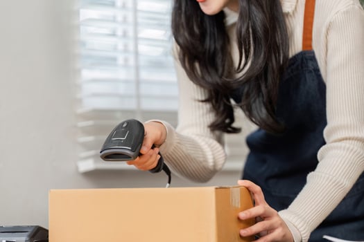 Woman utilizing a barcode scanner to efficiently deliver merchandise in a modern workspace photo