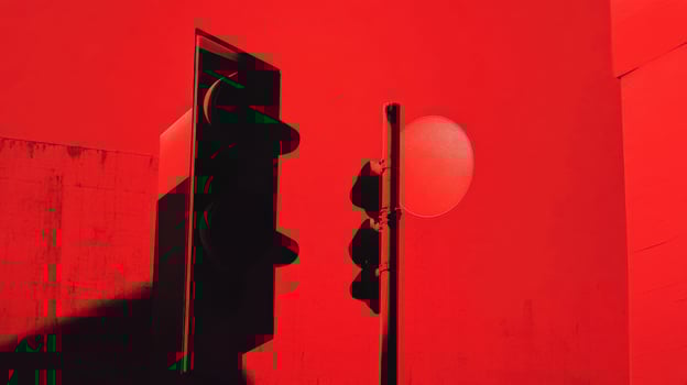 Bright red traffic light against a stark wall creates a striking urban visual at dusk photo
