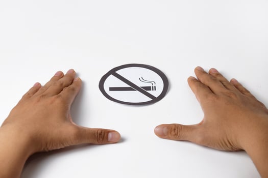 Paper no smoking sign in human hands photo