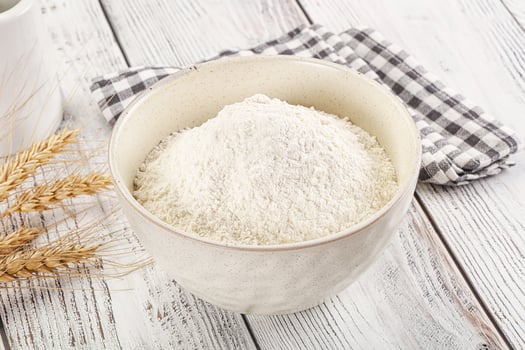 A bowl of flour next to a cup of coffee photo