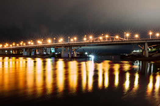 A bridge over a river at night with lights on it photo