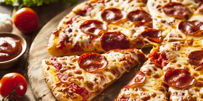 Classic pepperoni pizza with melted mozzarella cheese and crispy crust, served on a wooden board with fresh tomatoes and marinara sauce in the background photo