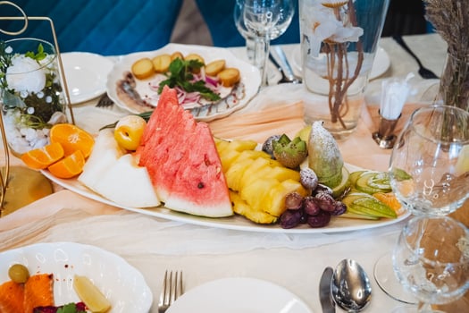 A beautifully arranged Assorted Fresh Fruit Platter featuring juicy Watermelon, sweet Pineapple, and refreshing Grapes on an Elegant Dining Table photo