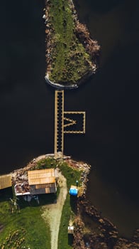 Aerial View of M Shaped Dock and Small Structures by Dark Water photo