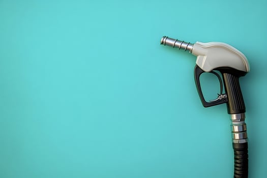 Fuel nozzle on turquoise background symbolizing gas price increase photo