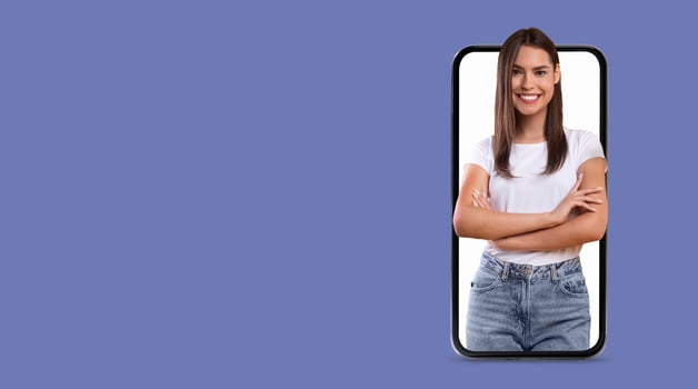 A young woman smiles confidently, with her arms crossed, displayed prominently on a smartphone screen. photo