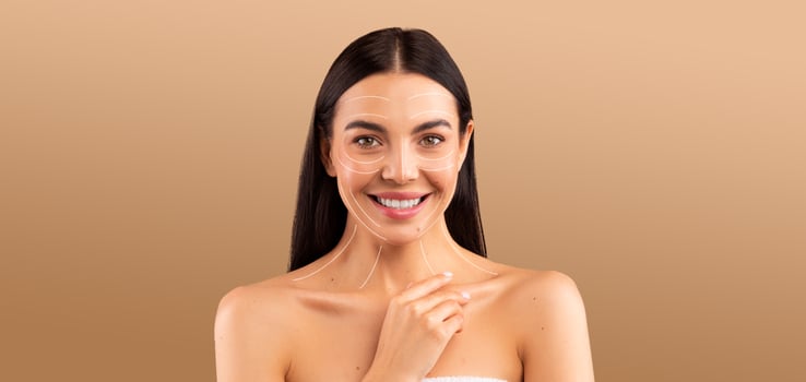 A woman enjoys her skin care routine, smiling happily while pampering herself. She appears relaxed and confident, embodying beauty and self-care in a serene environment. photo