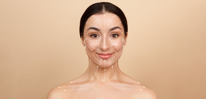 A woman engages in her skin care routine, surrounded by a minimalist background. She enjoys pampering herself, focusing on beauty and self-care. The atmosphere is peaceful and inviting. photo