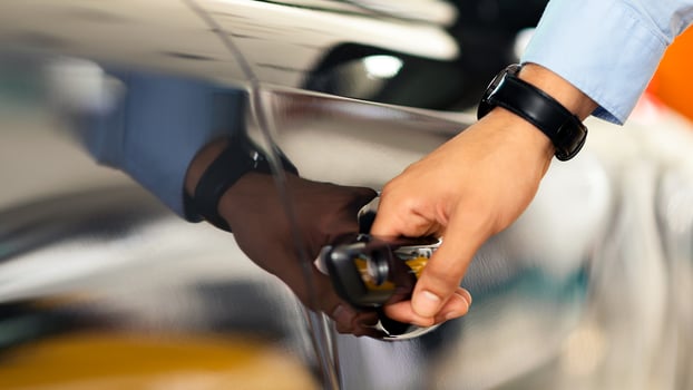 Unrecognizable man open car door, closeup of male hand with watch unlocking black auto door, making test drive at newest automobile showroom. Vehicle, transportation, car salon concept photo
