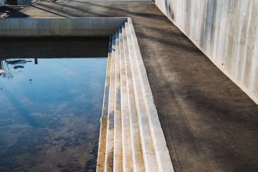 A beautifully designed concrete staircase descends into tranquil waters, creating an inviting setting that encourages immersion in natures captivating beauty and serenity photo