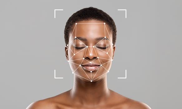 A person with closed eyes shows a calm expression as a facial recognition overlay highlights unique facial features. The background is neutral, emphasizing the subject and technology used. photo