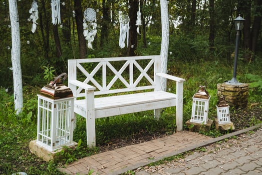 In the midst of a serene forest, a striking white bench stands as a perfect spot for visitors to pause, reflect, and fully enjoy the breathtaking beauty of the surrounding nature photo