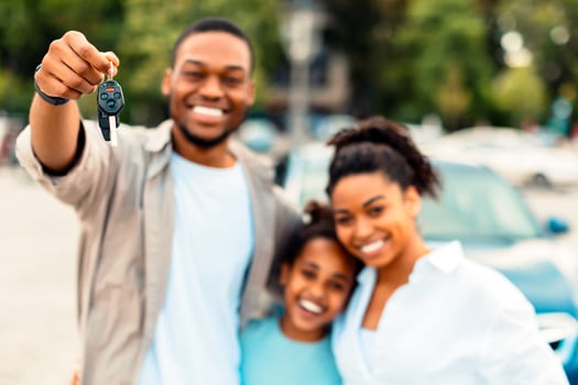 Joyful African American Family Showing New Car Key Smiling To Camera Standing Outdoors. Automobile Purchase And Rent, Vehicle Dealership Advertisement. Selective Focus On Auto Keys photo