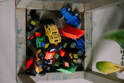 Pile of colorful toy trucks and blocks in a metal container, perfect for playtime so nice so photo