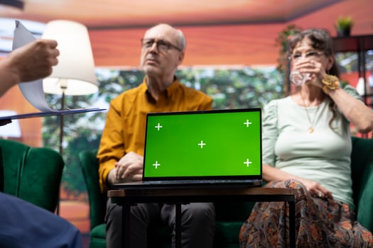 Caregiver nurse consulting senior couple next to chroma key mockup display on laptop, discussing about medical treatment and prescription. Specialist offering support and assistance. photo