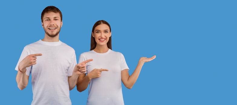 Cool Offer. Smiling couple pointing aside at copyspace for your advert, text or logo, pastel purple studio wall, panorama photo