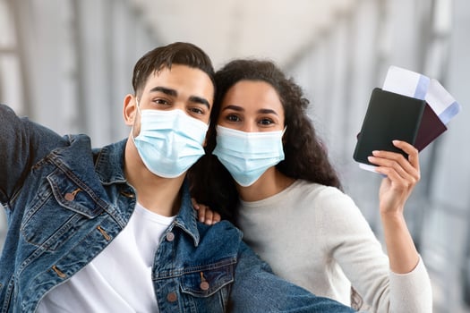 COVID-19 Travels. Happy Arab Couple In Protective Medical Mask Taking Selfie Photo In Airport, Young Middle Eastern Spouses Posing In Terminal With Passports And Tickets In Hands, Closeup Shot