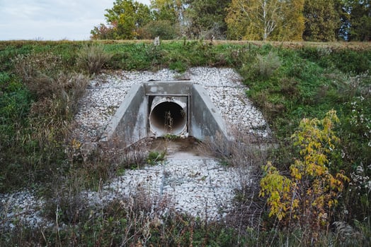 A rustic drainage tunnel, encircled by lush vegetation, beautifully contrasts the vibrant autumn landscape, showcasing natures allure photo