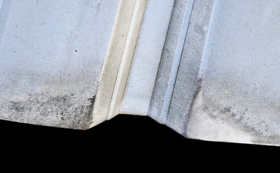 Close up dusty thin metal asbestos roof material object isolated on horizontal background. photo
