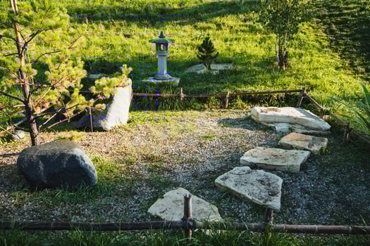 In the center of the garden, there stands a beautiful lantern, illuminating the area with its soft glow and enhancing the overall ambiance of the natural landscape that surrounds it photo