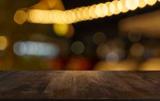 empty wooden table top on blurred background of night city street photo