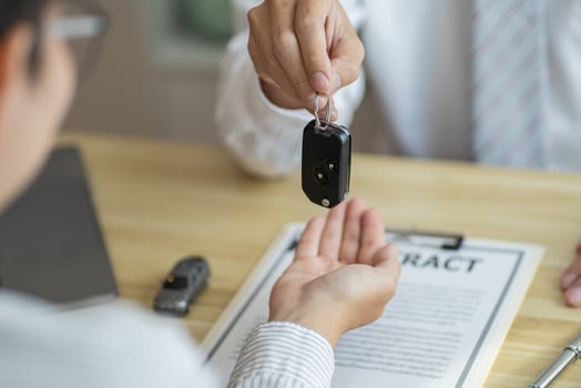 a man handing a car key to a woman photo