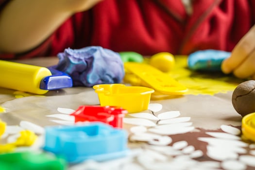 Unrecognizable child playing with plasticine dish photo