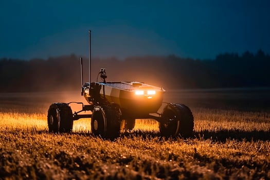 Ground based military drone operates in a field under evening light. photo