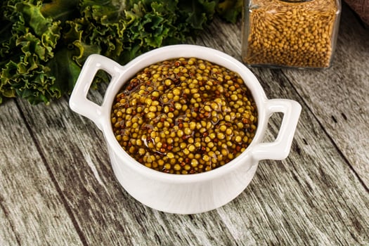 A bowl of mustard and a jar of mustard photo