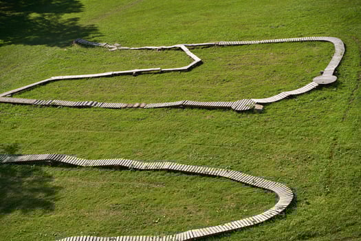 Curving wooden bike path on green grass in sunlit park. photo