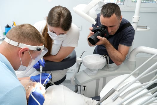photographer takes pictures of dental treatment process videographer shoots man Dental treatment. Woman on dental examination. Professional equipment in dental clinic photo