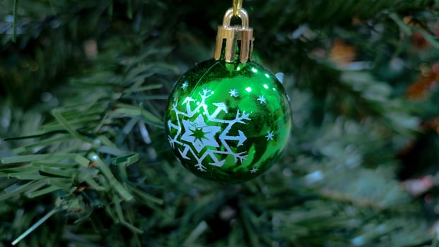 Background from a Christmas tree decorated in red and gold color close-up. Greeting card from a Christmas tree with red decorations and copy space. photo