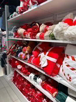 Shelves in shop filled with bright red and festive Christmas holiday blankets and decor items. Cheerful and seasonal atmosphere in the store photo