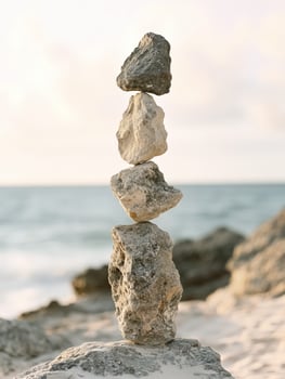 Balancing rocks on beach shore at sunset creates serene atmosphere photo