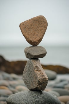 Balanced stones stacked on a rocky shore near the water's edge photo