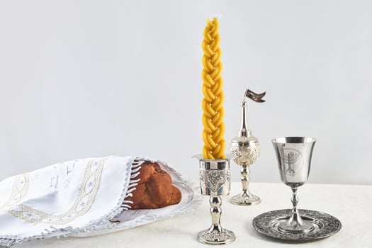 Shabbat Table Setting. Challah bread, braided candle and silver Kiddush cup, photo