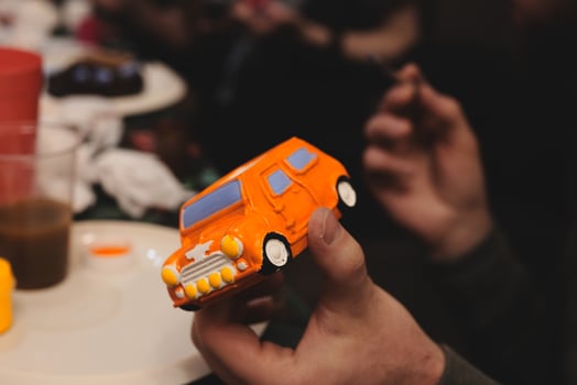 A person joyfully holds a colorful toy van that brings happiness and is perfect for playtime photo