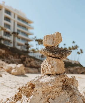 Natural rock sculpture at a sunny beach with palm trees in the background photo