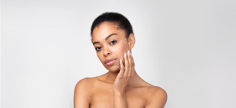 African American woman practices her skincare regimen, applying product gently on her face. She is isolated in a clean, bright space, emphasizing her commitment to self-care and beauty. photo