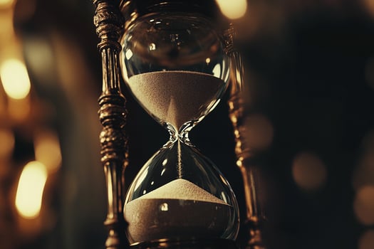 Antique hourglass with intricate golden details and flowing sand in glowing bokeh background photo