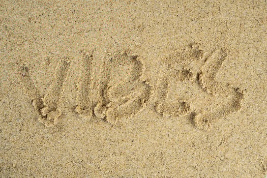 word vibes written on the beach sand photo
