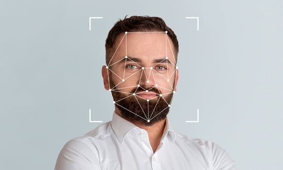 A man with a beard displays a neutral expression while facial recognition technology analyzes his features on a plain background. This modern approach enhances identification processes. photo
