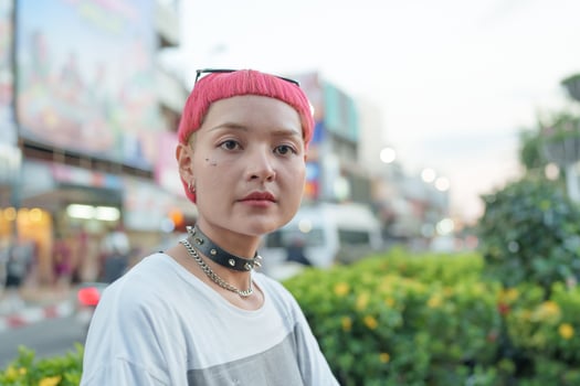 a woman with pink hair and a necklace photo