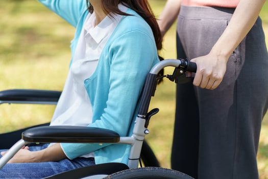 a sad woman in a wheelchair with a woman standing next to her photo