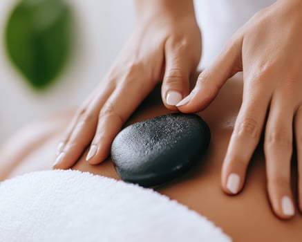 calm and peaceful spa treatment featuring hot stone massage on person back, promoting relaxation and wellness. soothing atmosphere enhances experience photo