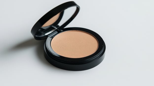 Compact powder arranged with the lid slightly open on a clean white background. photo