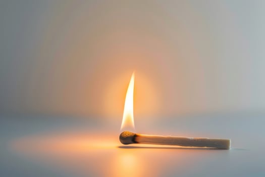 A match is lit and the flame is on the side of the match photo