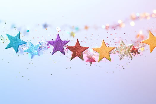Colorful Glittery Star Garland on Soft Pastel Background photo