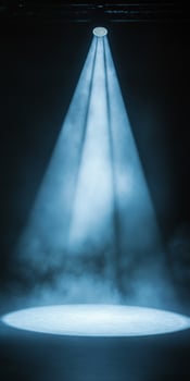 Soft Blue Spotlight Illuminating Stage Surface in Dark Setting photo